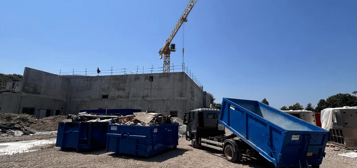 Chantier de construction avec grue et bennes en Alsace.